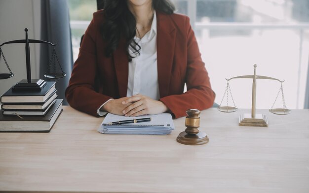 Geschäftsleute und Anwälte diskutieren Vertragspapiere mit Messingwaage auf dem Schreibtisch im Büro Rechtsdienstleistungen Beratung Justiz und Recht Konzeptbild mit Filmgrain-Effekt