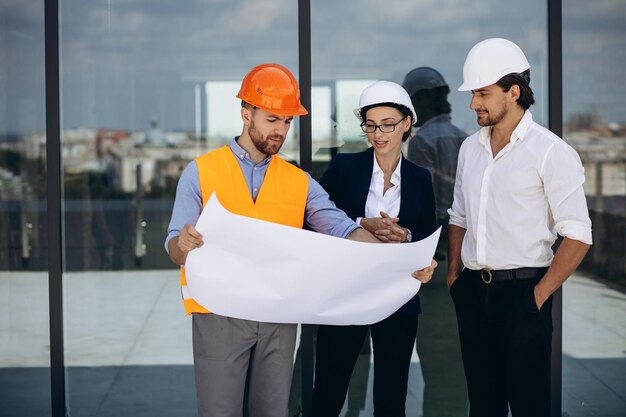 Geschäftsleute und Ingenieure unterhalten sich auf dem Dach des Gebäudes