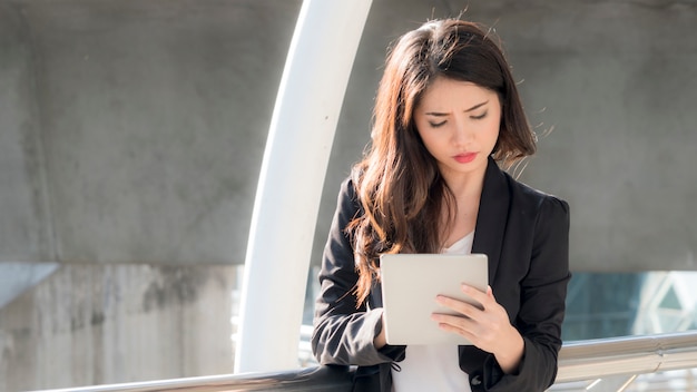 Geschäftsmädchen mit intelligenten Tablet-Geräten und Stadt