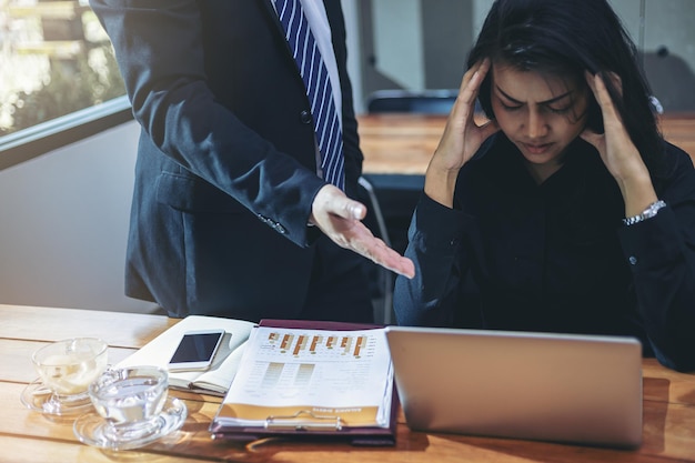 Geschäftsmann als Chef machte die Sekretärin für ihre Arbeit verantwortlich und hatte Kopfschmerzen im Büro