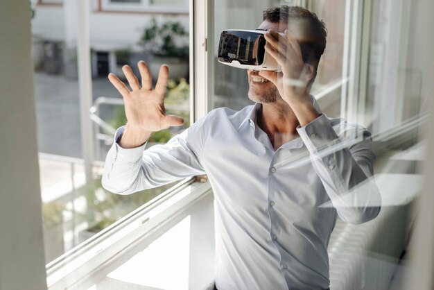 Geschäftsmann am Fenster mit VR-Brille