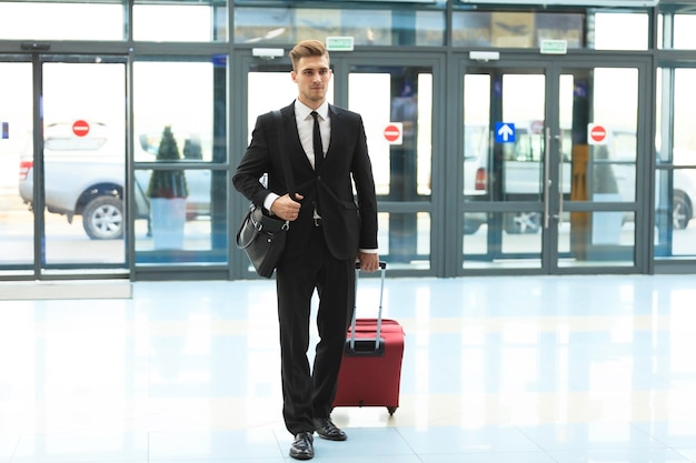 Geschäftsmann am Flughafen mit Koffer - Reisekonzept