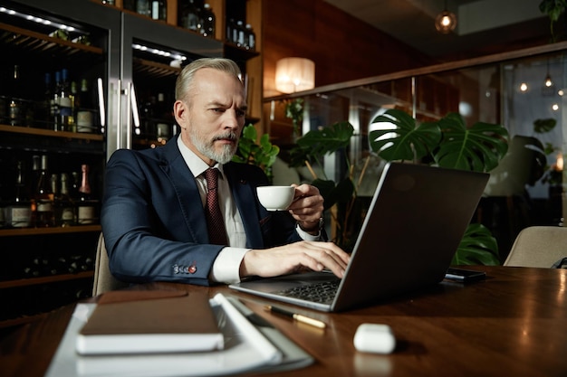 Geschäftsmann arbeitet online am Laptop im Café