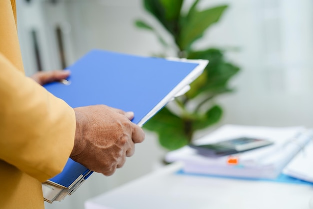 Geschäftsmann arbeitet und bereitet Papierkramberichtsdaten vor, um Informationen im Aktenordner im Büro zu analysieren