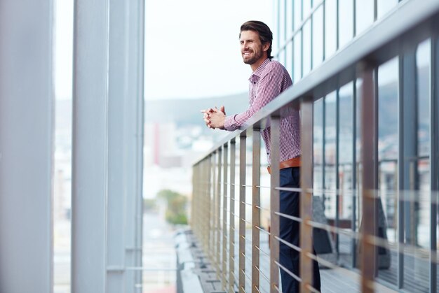 Geschäftsmann Balkon oder Denken an Ideen im Gebäude für Lösung Betrachtung oder Reflexion mit Lächeln Stadt Relator oder glücklicher Immobilienmakler mit Mission Vertrauen oder Traum für städtische Immobilien
