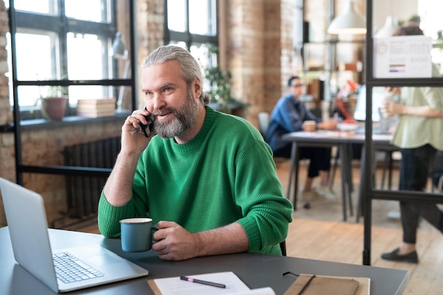 Geschäftsmann, der am Handy im Büro spricht