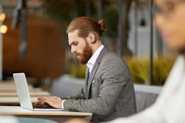 Geschäftsmann, der am Laptop im Café arbeitet