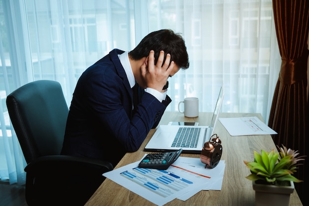 Geschäftsmann, der am Schreibtisch im Büro arbeitet