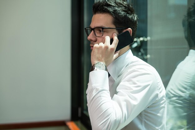 Geschäftsmann, der am Telefon im Büro spricht