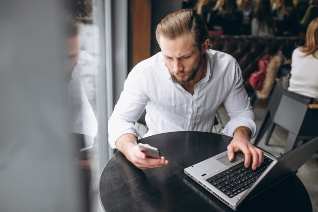 Geschäftsmann, der an Computer in einem Café arbeitet