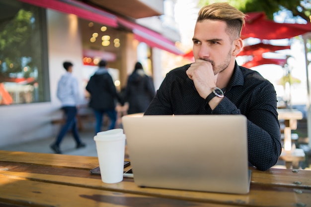 Geschäftsmann, der an seinem Laptop arbeitet.