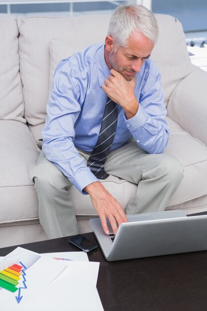 Geschäftsmann, der Arbeit mit seinem Laptop erledigt