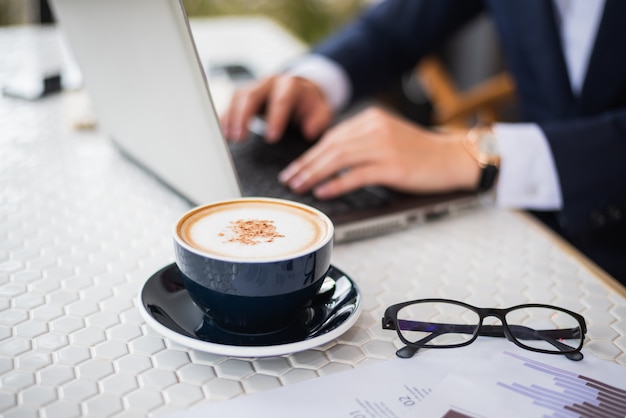 Geschäftsmann, der auf dem Tisch mit Laptop arbeitet