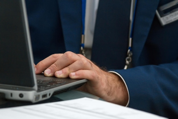 Geschäftsmann, der auf einer Konferenz an einem Laptop arbeitet - Nahaufnahme