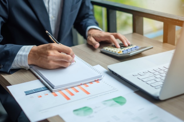 Geschäftsmann, der calcultor für Analyse mueting Plan verwendet