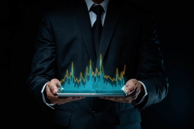 Geschäftsmann, der digitales Marketing der Tablettplanung mit Diagrammhologrammeffekt verwendet