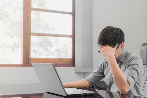 Geschäftsmann, der Druck mit der Laptop-Computer arbeitet im Büro hat