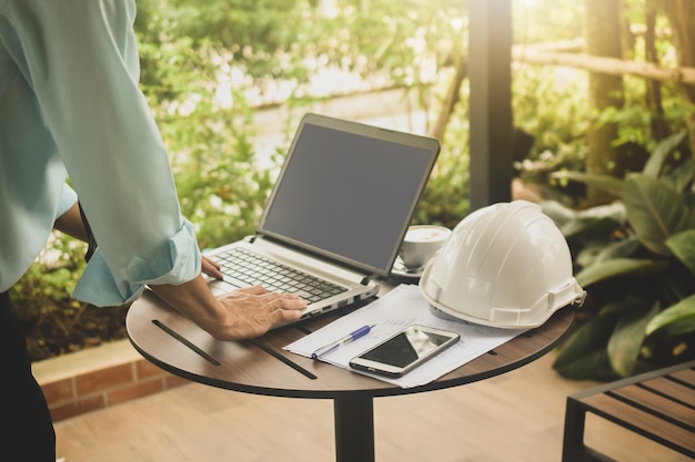 Geschäftsmann, der durch Computerarbeit am Café arbeitet