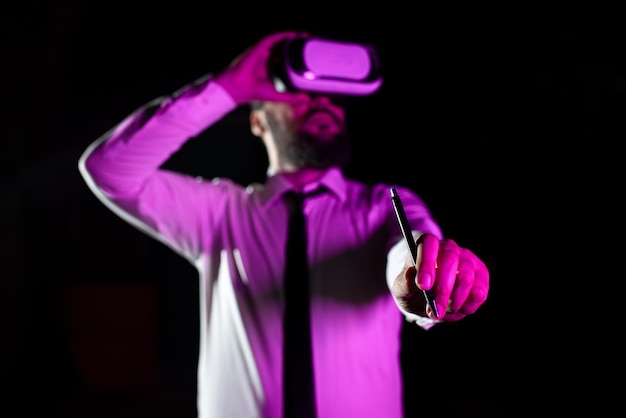 Geschäftsmann, der ein Headset mit Stift trägt, während er eine Berufsausbildung durch das Tragen eines Virtual-Reality-Simulators macht, der auf einen Mann fällt, der futuristische Technologie präsentiert