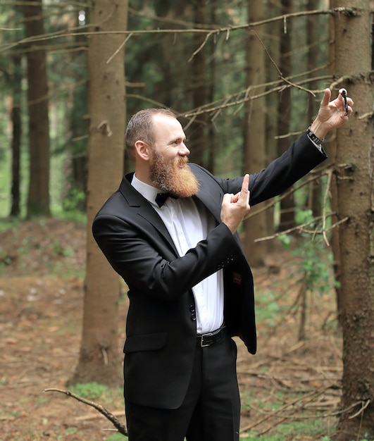 Geschäftsmann, der ein Selfie in einem Kiefernwald nimmt