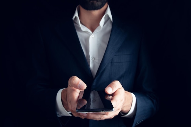 Geschäftsmann, der ein Telefon in seiner Hand hält