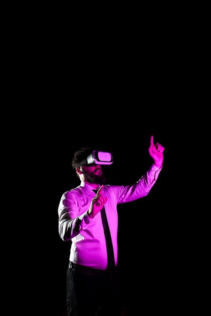 Geschäftsmann, der eine Virtual-Reality-Brille verwendet, gestikuliert, während er ein professionelles Trainingslicht nimmt, das auf einen Mann fällt, der einen Simulator erlebt und moderne Technologie präsentiert