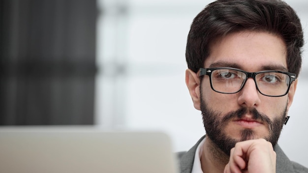 Geschäftsmann, der einen Laptop verwendet, während er spät in seinem Büro arbeitet