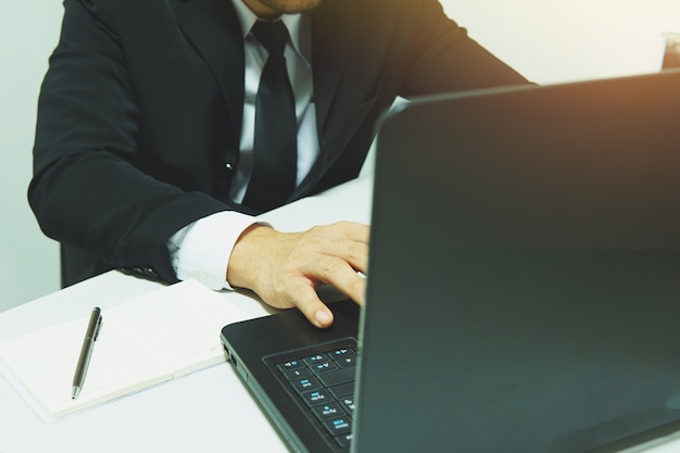 Geschäftsmann, der im Büro mit Laptop arbeitet