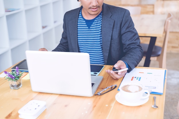 Geschäftsmann, der im Büro mit Laptop und Dokumenten auf seinem Schreibtisch, Berateranwalt Co arbeitet