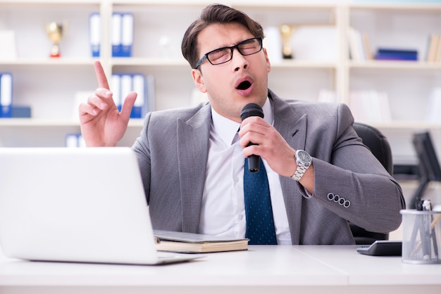 Geschäftsmann, der im Büro singt