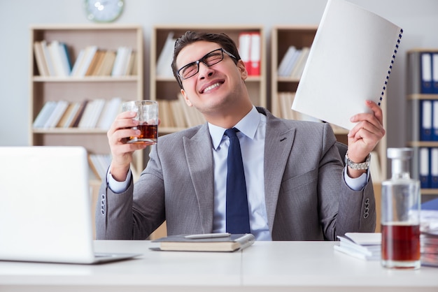 Geschäftsmann, der im Büro trinkt