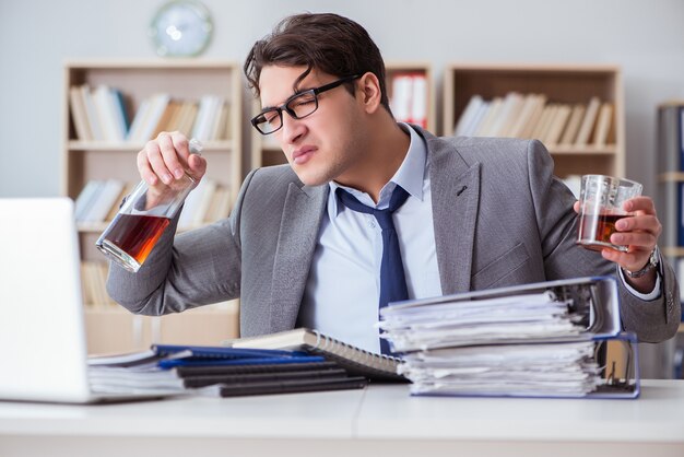 Geschäftsmann, der im Büro trinkt