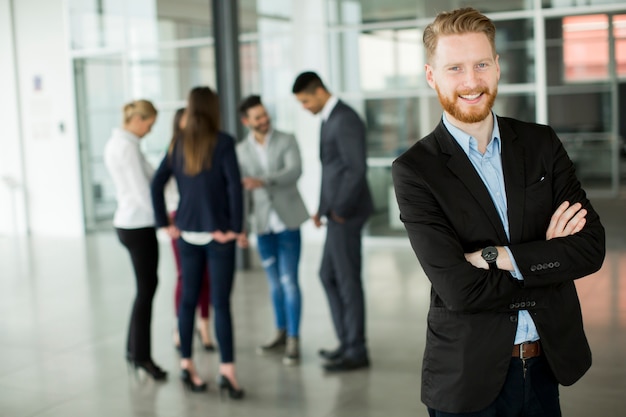 Geschäftsmann, der im Büro und in anderen Geschäftsleuten spricht steht