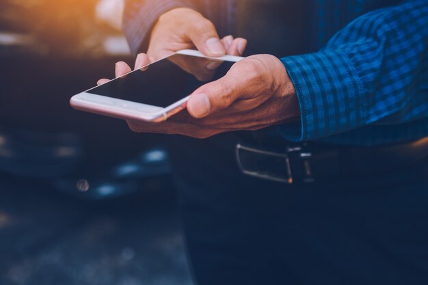 Geschäftsmann, der intelligentes Telefon hält und Internet online verwendet