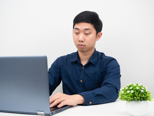 Geschäftsmann, der Laptop auf dem Tisch verwendet, um online zu arbeiten und sich versucht zu fühlen, will schlafen
