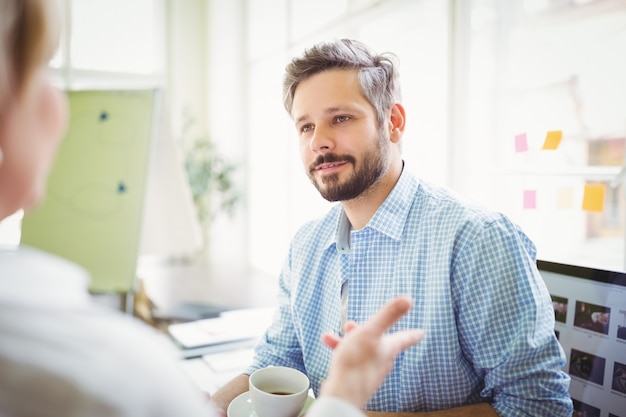 Geschäftsmann, der mit Kollegen im kreativen Büro sich bespricht