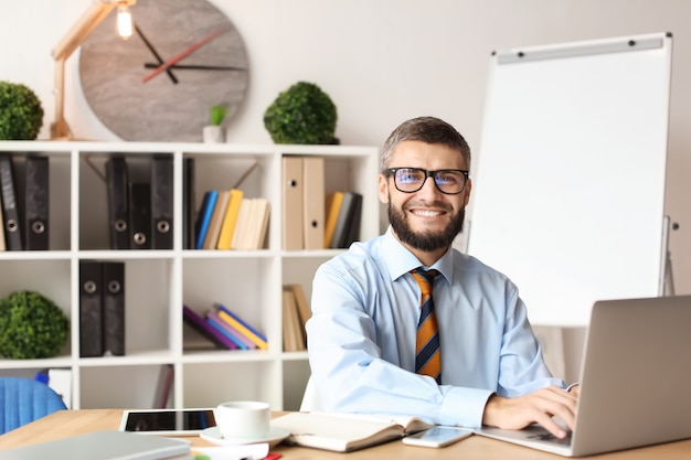 Geschäftsmann, der mit Laptop im Büro arbeitet