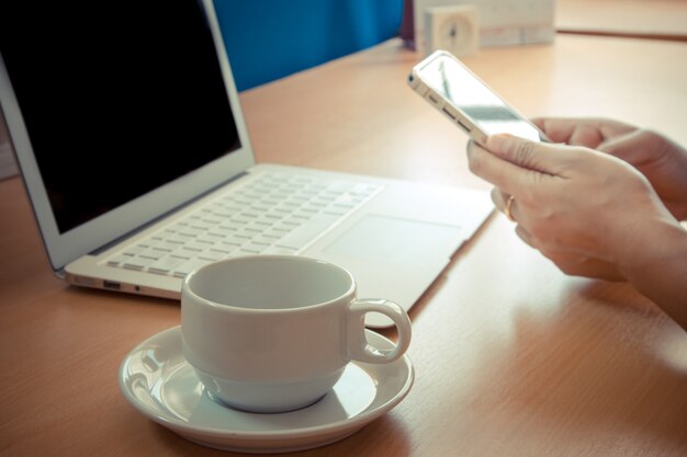 Geschäftsmann, der mit modernen Geräten, digitalem Notebook und Mobiltelefon arbeitet.