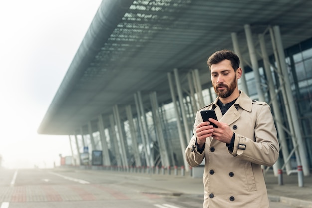 Geschäftsmann, der Smartphone beim Gehen verwendet