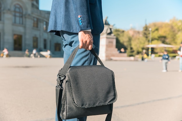 Geschäftsmann, der Tasche in der Straße hält