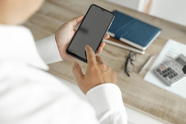 Geschäftsmann, der Telefon verwendet, um Geschäftsinvestitionsmann im weißen Hemd zu kommunizieren, das im Büro steht