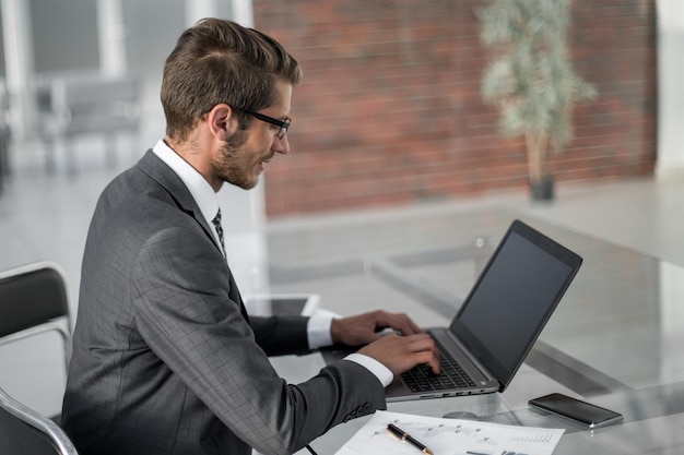 Geschäftsmann, der Text auf Laptop schreibt