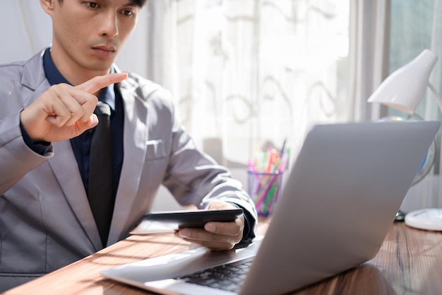 Geschäftsmann, der vor einem Notebook-Computer an einem Schreibtisch arbeitet