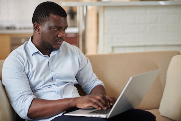 Geschäftsmann, der zu Hause am Laptop arbeitet