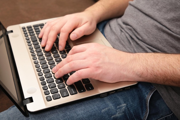 Geschäftsmann, der zu Hause mit einem Laptop auf dem Sofa arbeitet.