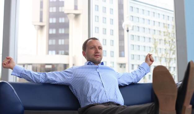 Geschäftsmann entspannt sich im Büro mit seinen Schuhen auf dem Schreibtisch