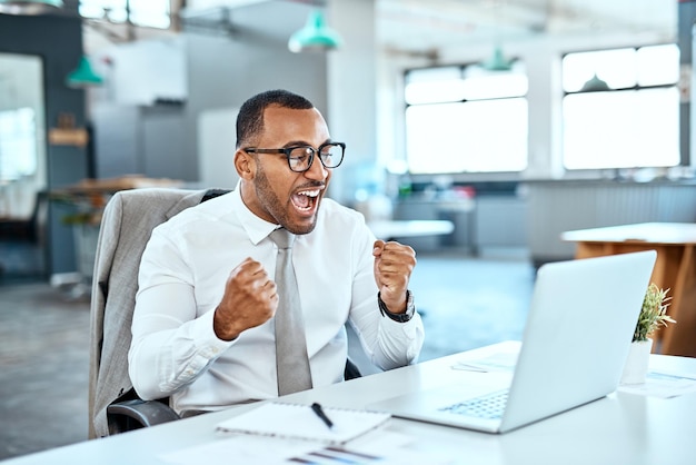 Geschäftsmann gewinnt und ja auf Computer-Erfolgsnachrichten oder Bonus bei der Feier, Jubel und Wow im Büro. Aufgeregt feiern Faust und Gewinner, Mitarbeiter oder Person auf Laptop-Werbeverkäufen oder -Ergebnissen