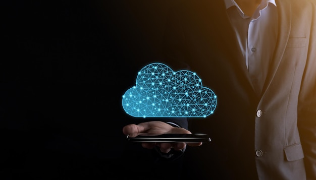 Geschäftsmann hält Cloud-Symbol. Cloud-Computing-Konzept - Smartphone mit Cloud verbinden. Computernetzwerk-Informationstechnologe mit Smartphone.Big Data Concept.Low Poly, polygonal