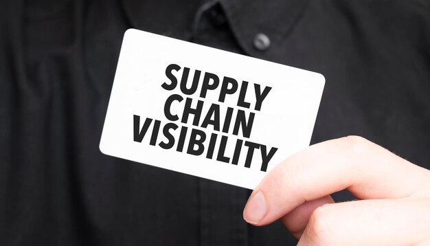 Geschäftsmann hält eine Karte mit dem Text SUPPLY CHAIN VISIBILITY Geschäftskonzept