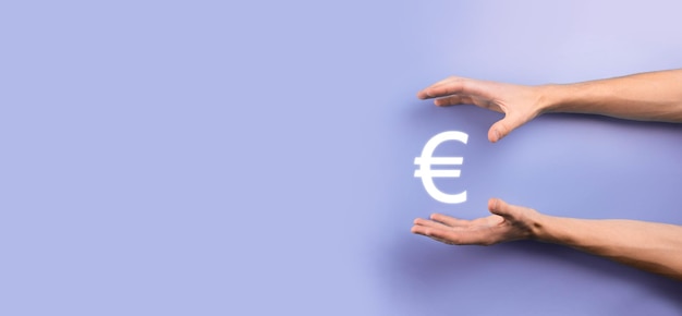 Geschäftsmann hält Geldmünzensymbole EUR oder Euro auf dunklem Hintergrund. Wachsendes Geldkonzept für Geschäftsinvestitionen und Finanzen.